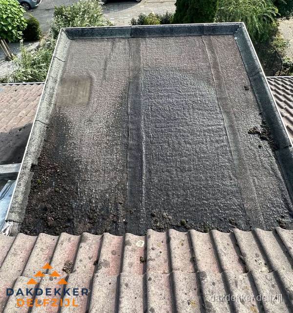 Verouderd plat dak met bitumen en slijtage voor lekkage inspectie in Delfzijl Verouderd plat dak met bitumen en slijtage voor lekkage inspectie in Delfzijl