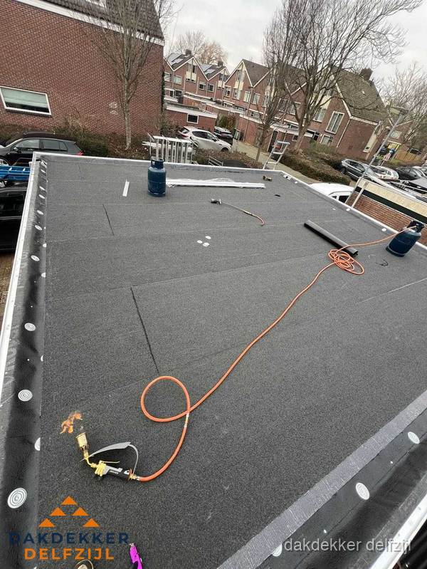 Afgewerkte dakrenovatie met bitumen op plat dak in Delfzijl