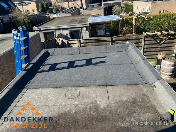 Dakdekker bij bitumen plat dak renovatie in Delfzijl Dakdekker bij bitumen plat dak renovatie in Delfzijl