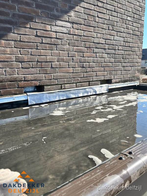 Stilstaand water op plat dak door slechte afwatering in Delfzijl