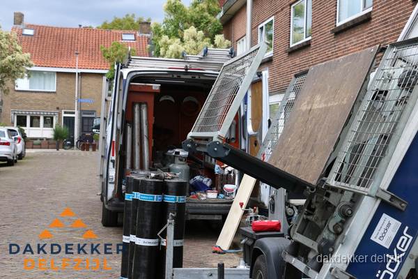 Dakdekkersbusje met materiaal en ladderlift voor dakpannen vervangen in Delfzijl