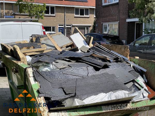 Afvalcontainer met gesloopt dakmateriaal tijdens dakkapel renovatie in Delfzijl Afvalcontainer met gesloopt dakmateriaal tijdens dakkapel renovatie in Delfzijl