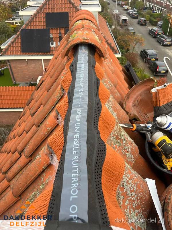 Dakdekker vervangt nokvorst met ruiterrol op pannendak in Delfzijl