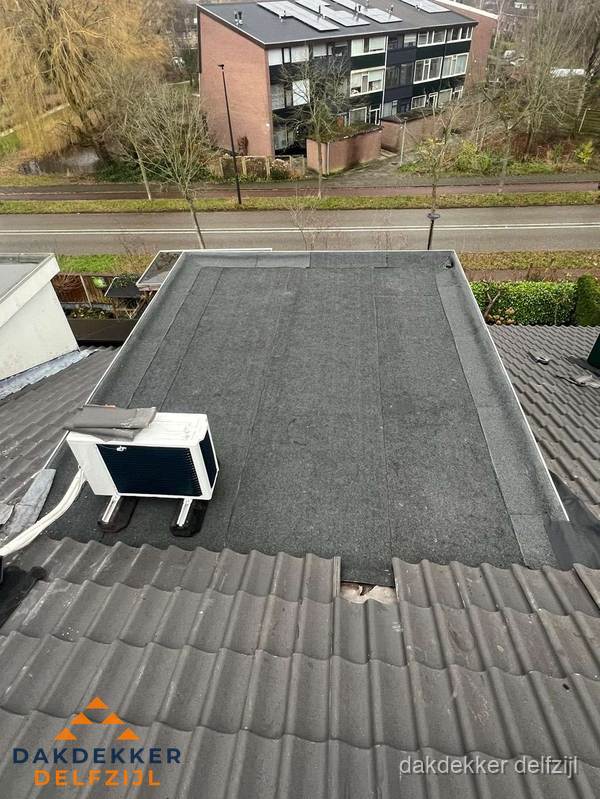 Plat dak inspectie met bitumen bedekking naast schuin pannendak in Delfzijl Plat dak inspectie met bitumen bedekking naast schuin pannendak in Delfzijl