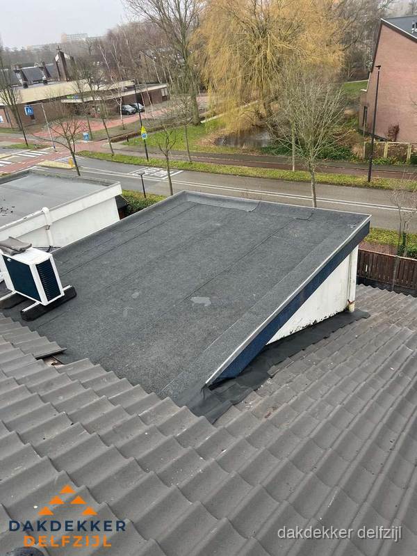Plat dak met bitumen dakbedekking naast schuin pannendak in Delfzijl Plat dak met bitumen dakbedekking naast schuin pannendak in Delfzijl
