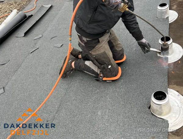 Dakdekker repareert bitumen dakleer bij dakdoorvoer in Delfzijl Dakdekker repareert bitumen dakleer bij dakdoorvoer in Delfzijl