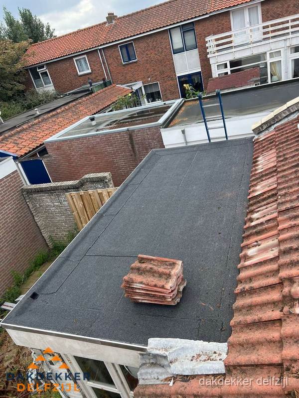 Aanbouw plat dak met reservepannen voor dakpannen vervangen in Delfzijl