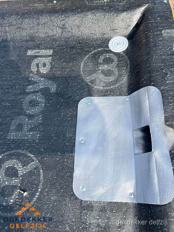 Dakdoorvoer met metalen afvoerplaat op bitumen dak in Delfzijl