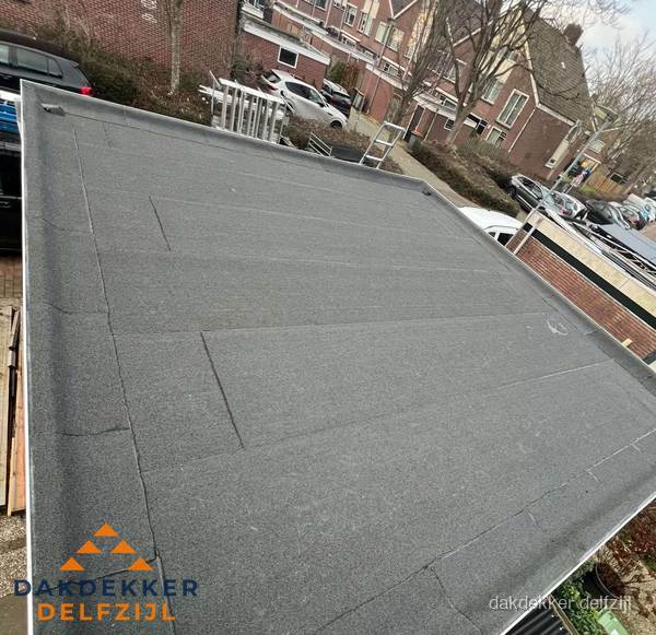 Nieuwe bitumen dakbedekking op plat dak van garage in Delfzijl