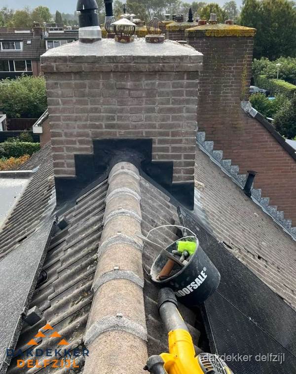 Schoorsteen met loodaansluiting en nokvorst op pannendak in Delfzijl Schoorsteen met loodaansluiting en nokvorst op pannendak in Delfzijl